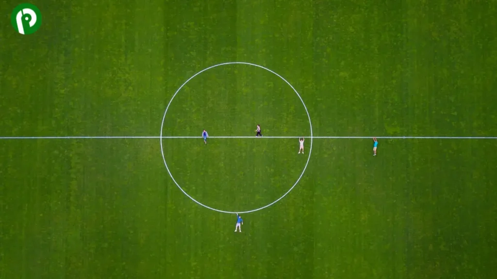 Top-down view of the center of a football field, showing the center circle and halfway line without end zones.