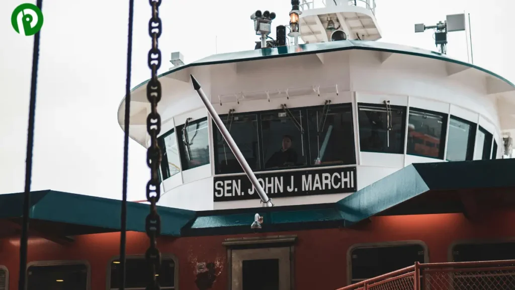 Tugboat Sen. John J. Marchi seen from the dock with a person inside the control deck.