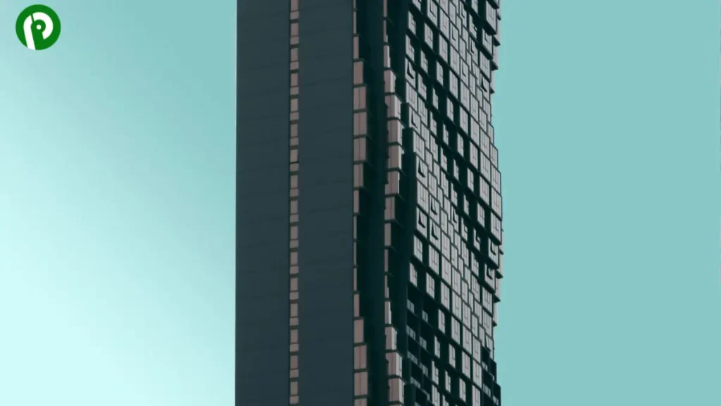 Tall modern skyscraper with geometric window design set against a pale blue sky.