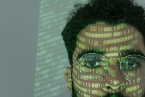 Close-up of a man's face with green binary code projected on his skin and glasses, symbolizing AI web crawling, machine learning, and futuristic data analysis in 2025.