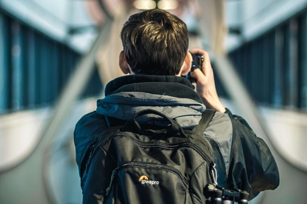 A man with a backpack and camera, symbolizing the tech-savvy, style-conscious modern explorer.