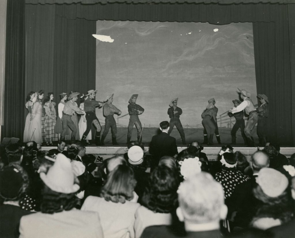Entertainers who paid the ultimate price performing during the Vietnam War — vintage black-and-white image of performers in cowboy costumes entertaining troops.