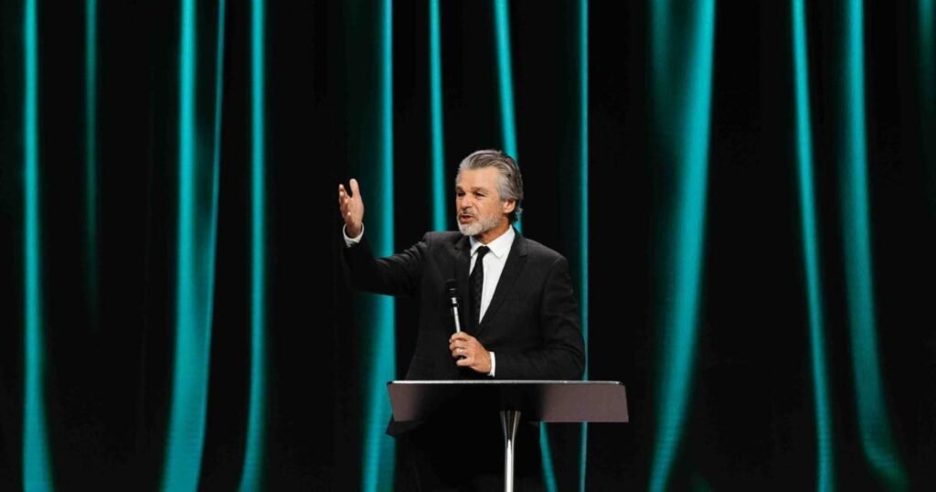 Pastor Jentezen Franklin speaking passionately on stage while holding a microphone.