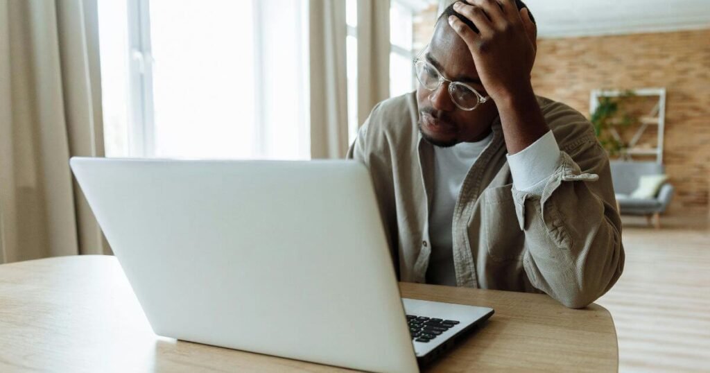 A person holding their head, symbolizing stress and challenges in complex systems.