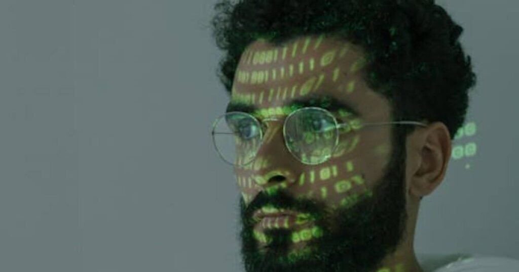 A face illuminated with green digital light representing data, identity, and futuristic interpretations.
