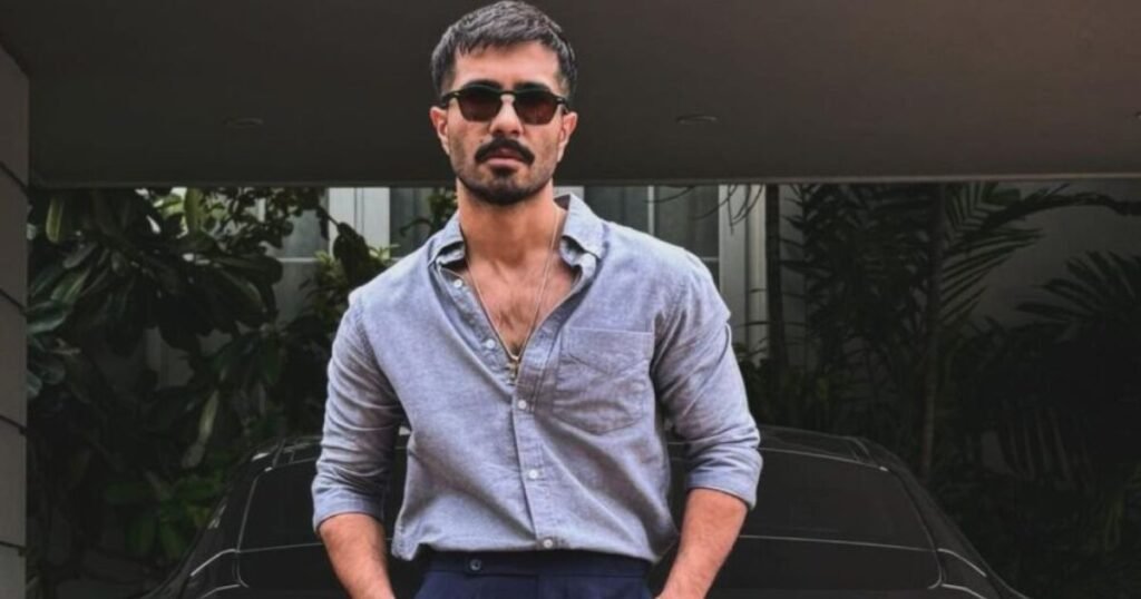 Feroze Khan in grey shirt and sunglasses posing confidently outdoors