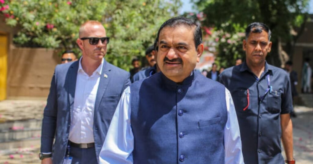 Gautam Adani walking with security and associates during a business visit